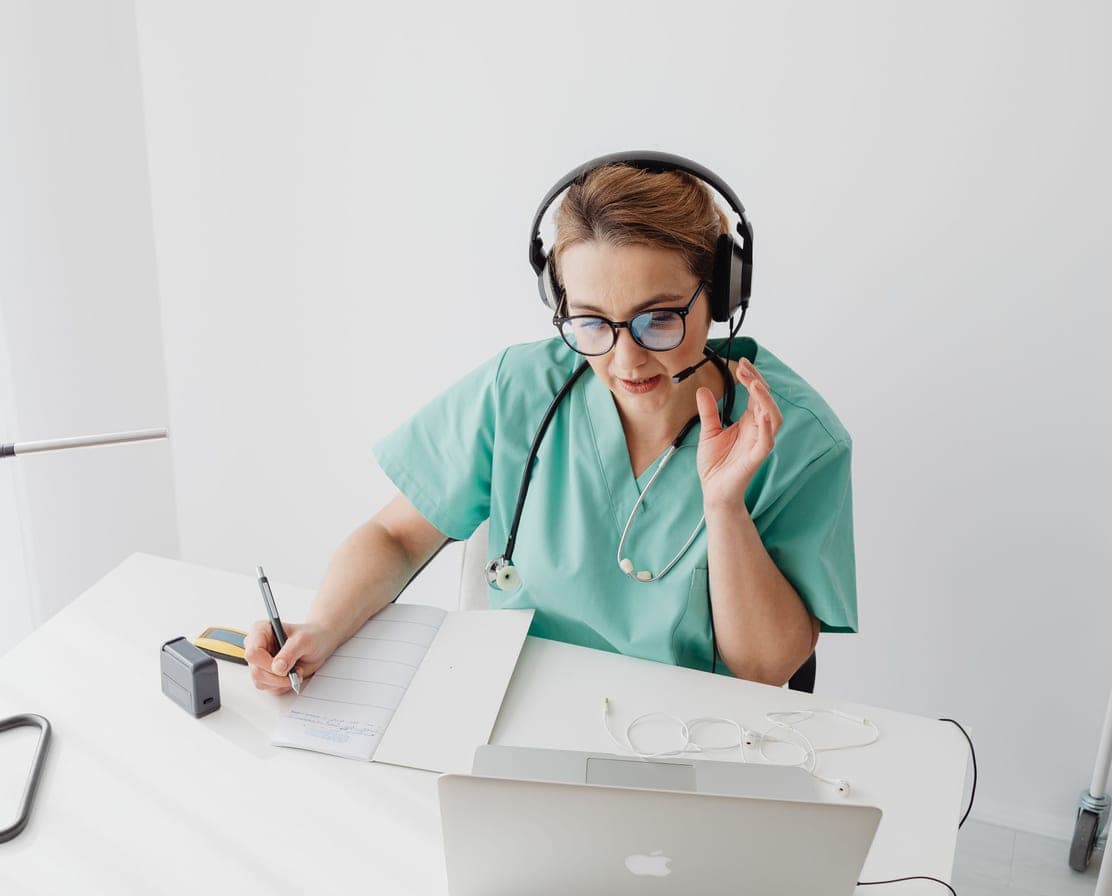 Clinic front-desk staff member taking a call on a headset
