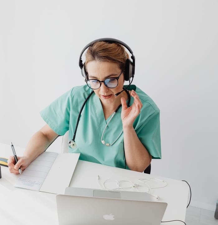 Clinic front-desk staff taking a patient call on a headset